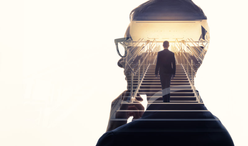 Double exposure of a businessman and stairs to illustrate employee growth.