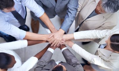 Shot of a group of coworkers with their hands in a huddle